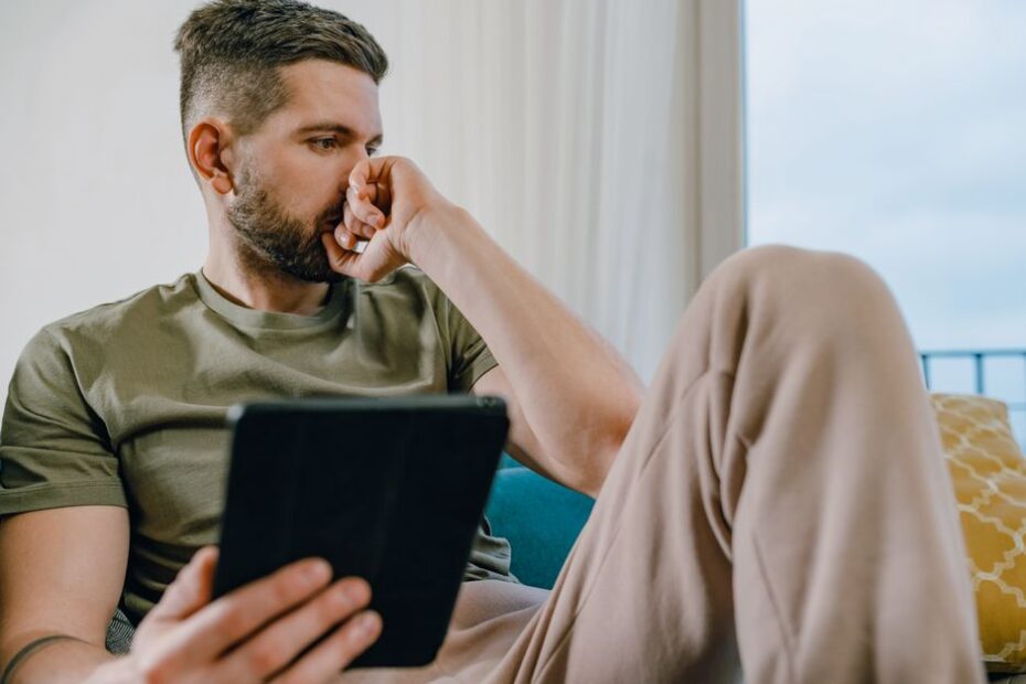 Real estate agent or home buyer stands in a bright, modern living room, using a tablet to analyze property data, symbolizi...