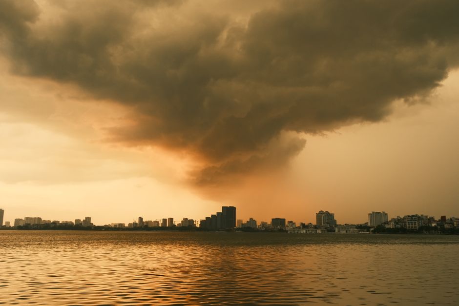 Dark, dramatic storm clouds gathering over a modern commercial building on the Gulf Coast, symbolizing the weather risks t...