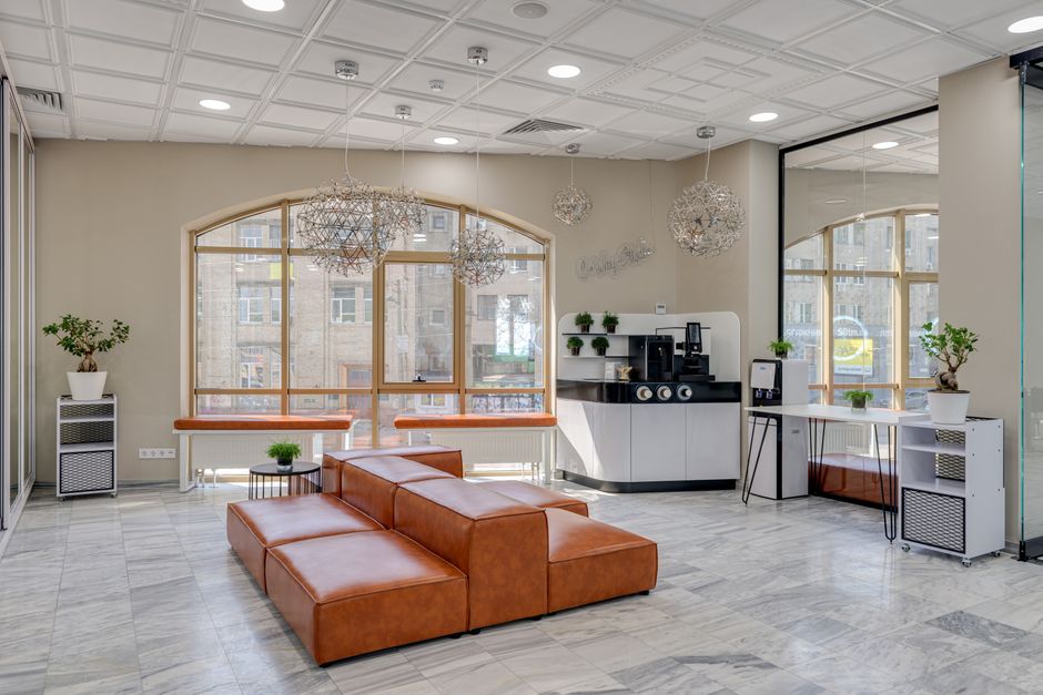 The sunlit, empty lobby of a modern commercial property featuring clean lines, minimalist furniture, and large windows, showcasing a desirable space for potential tenants.