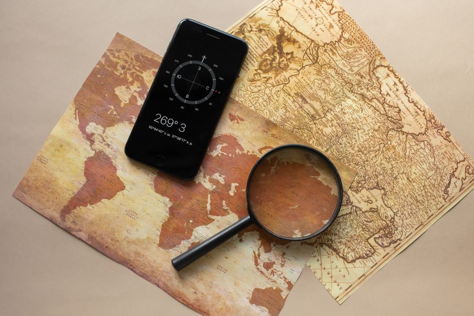 A top-down view of a person using a magnifying glass to inspect a specific location on a modern city map, representing local visibility analysis.